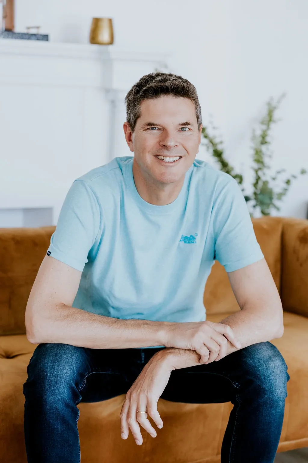 Luc Turell, magnétiseur, souriant chaleureusement vers l'objectif dans un intérieur lumineux.